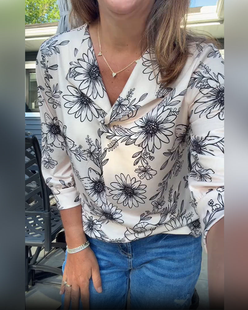 Blusa de color tinta, estampado floral, manga tres cuartos y solapa