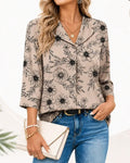 Blusa de color tinta, estampado floral, manga tres cuartos y solapa